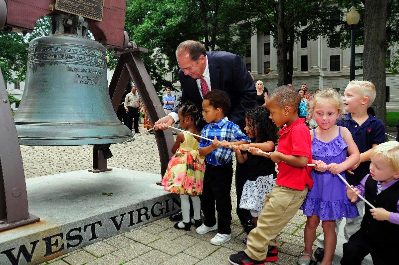 Gov. Tomblin and children ringing bell for MLK event.